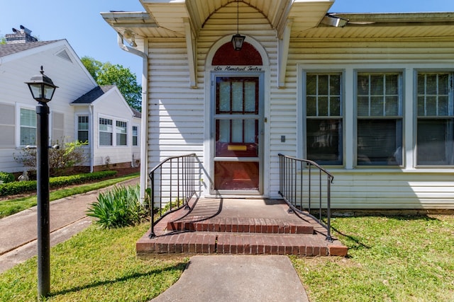 entrance to property featuring a lawn