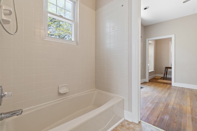 bathroom featuring tiled shower / bath and hardwood / wood-style flooring