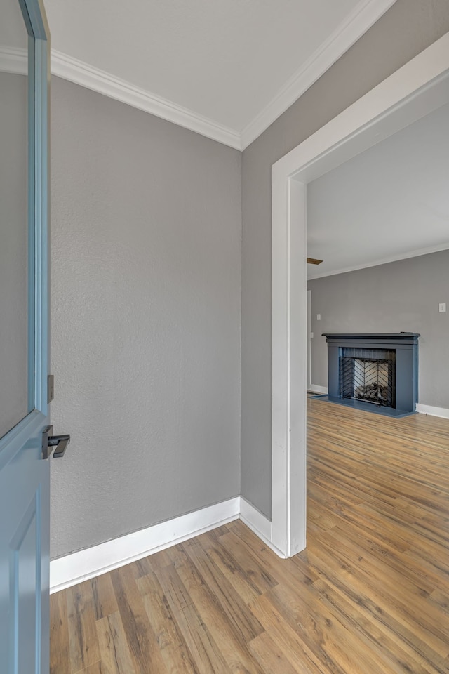 unfurnished living room featuring crown molding and hardwood / wood-style floors