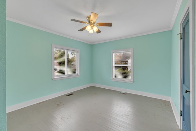 spare room featuring hardwood / wood-style floors, crown molding, and a healthy amount of sunlight