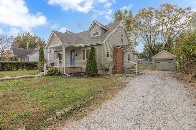 view of front of home with a front lawn, an outbuilding, a garage, and covered porch