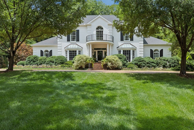 view of front facade with french doors, a front yard, and a balcony