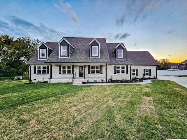 cape cod house with a lawn