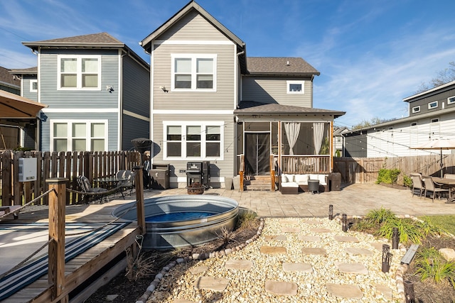 back of property featuring a patio area, outdoor lounge area, and a swimming pool