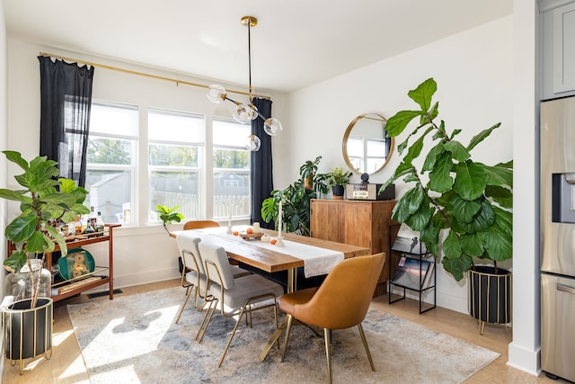 dining area with hardwood / wood-style floors and a chandelier