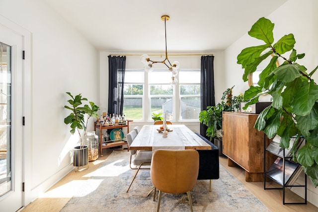 dining space featuring light hardwood / wood-style floors and an inviting chandelier