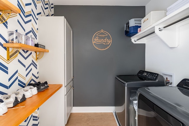 washroom featuring washer and clothes dryer and light hardwood / wood-style floors