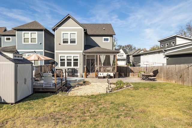 back of house featuring outdoor lounge area, a patio area, a yard, and a storage shed