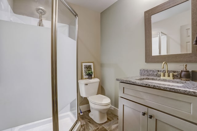 bathroom featuring a shower with door, toilet, and vanity