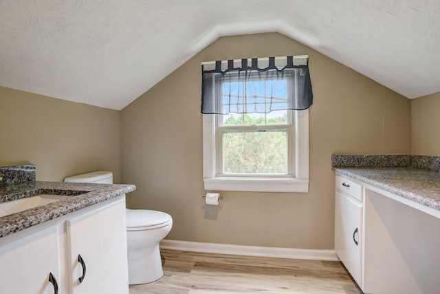 bathroom with a textured ceiling, toilet, lofted ceiling, vanity, and hardwood / wood-style flooring