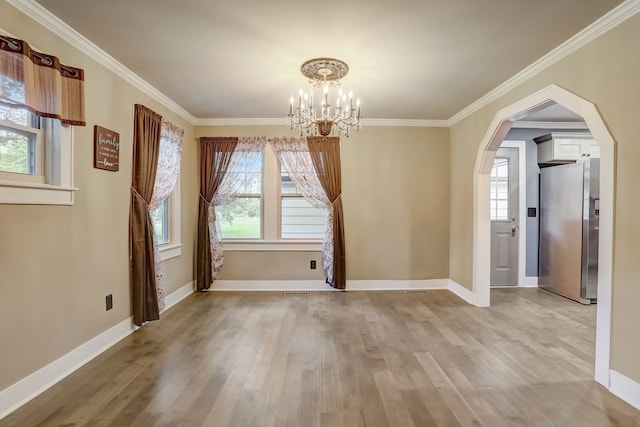 unfurnished dining area featuring a wealth of natural light, a notable chandelier, and light hardwood / wood-style floors