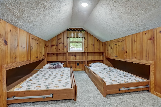 carpeted bedroom featuring wooden walls, vaulted ceiling, and a textured ceiling