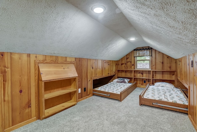 bedroom featuring wood walls, a textured ceiling, and light colored carpet