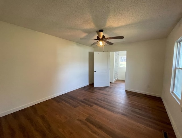 empty room featuring ceiling fan, a textured ceiling, and dark hardwood / wood-style flooring