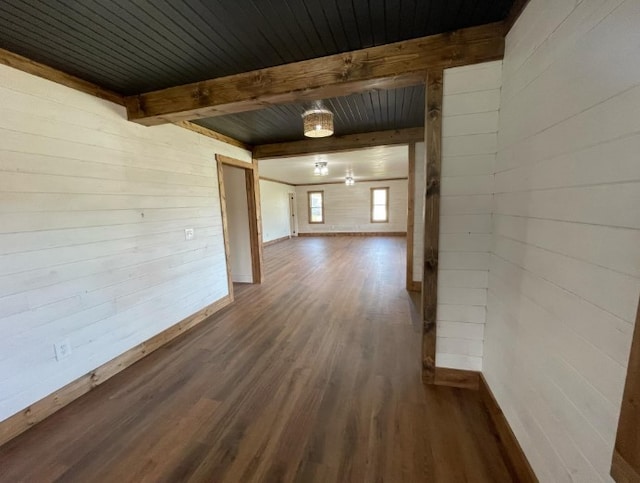 hallway with dark wood-type flooring, wooden ceiling, beamed ceiling, and wood walls