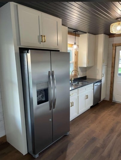 kitchen featuring stainless steel appliances, dark hardwood / wood-style floors, wood ceiling, sink, and white cabinets