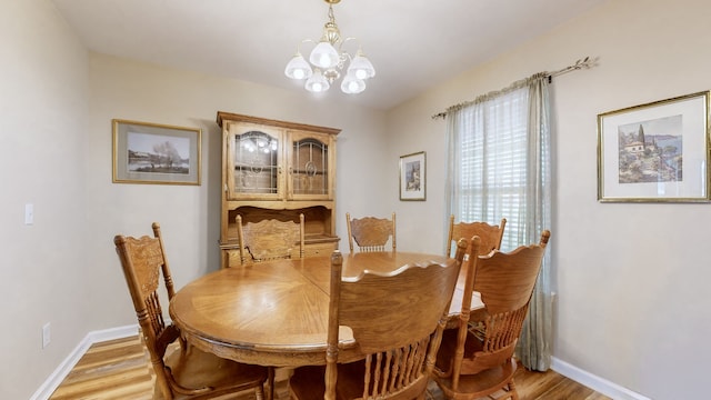 dining area featuring an inviting chandelier and light hardwood / wood-style flooring