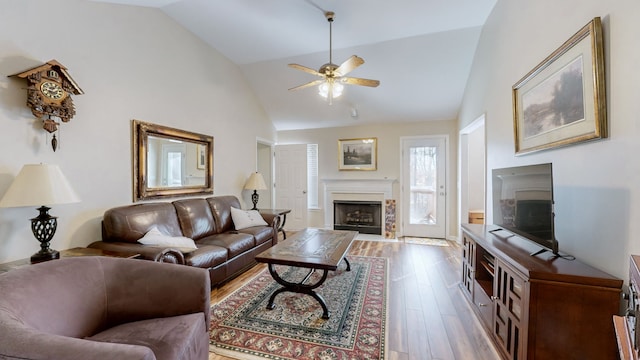 living room with ceiling fan, high vaulted ceiling, and light hardwood / wood-style flooring