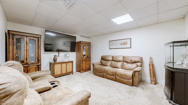 living room with a paneled ceiling and light colored carpet