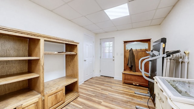 interior space with a paneled ceiling and light wood-type flooring