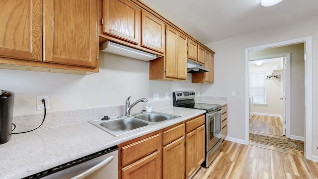 kitchen with appliances with stainless steel finishes, light wood-type flooring, and sink