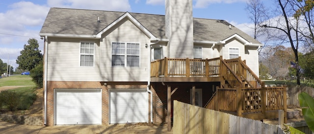 back of property featuring a garage and a deck