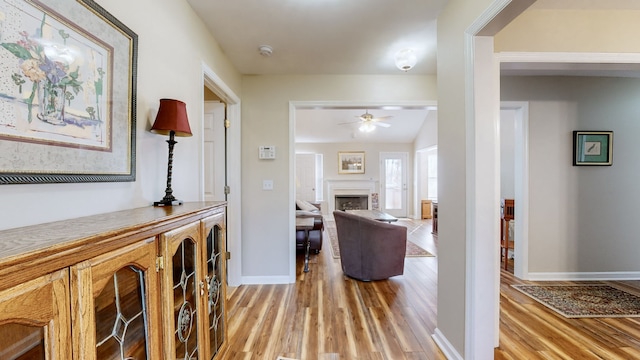 hall with light hardwood / wood-style floors and lofted ceiling