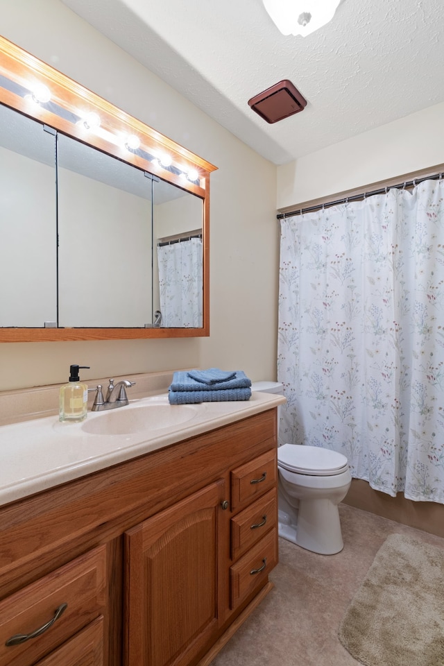 bathroom featuring vanity, a textured ceiling, and toilet