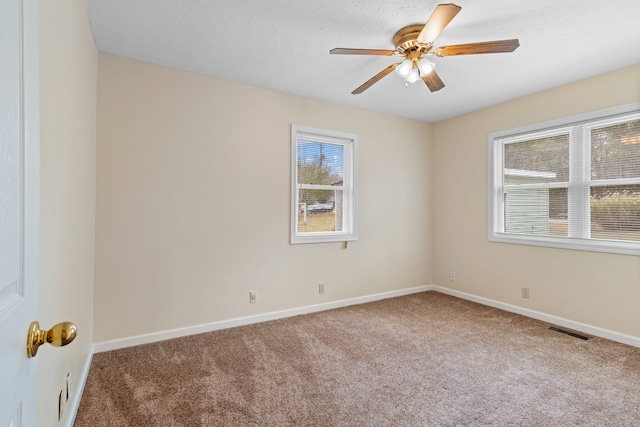 carpeted spare room featuring ceiling fan