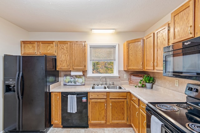 kitchen featuring a textured ceiling, sink, black appliances, and tasteful backsplash