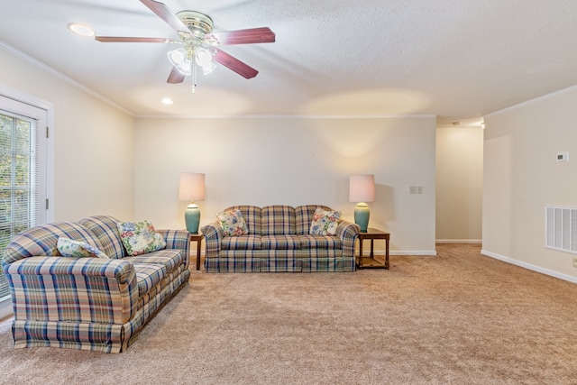 living room featuring ornamental molding, light colored carpet, a textured ceiling, and ceiling fan