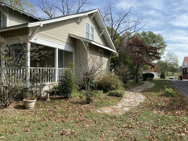 view of property exterior with a lawn and covered porch