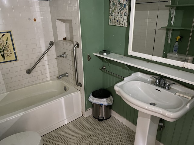 bathroom with tiled shower / bath, tile patterned floors, and toilet