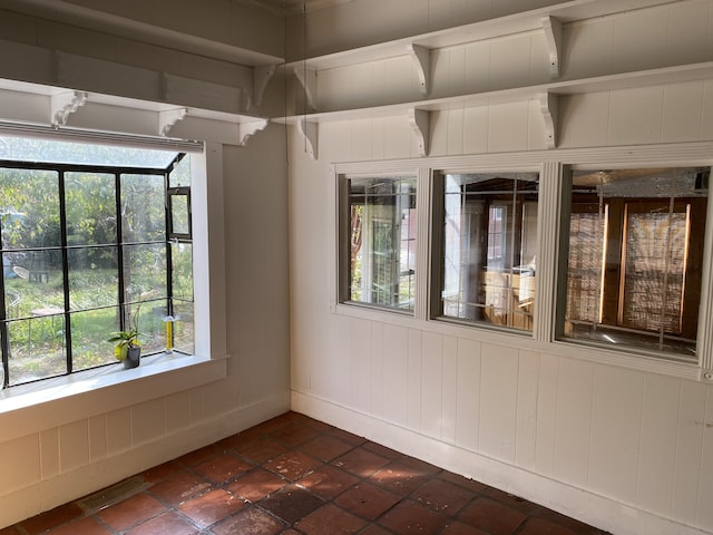 spare room featuring wood walls and plenty of natural light