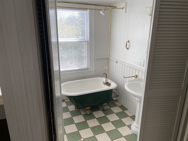 bathroom with a tub to relax in and plenty of natural light