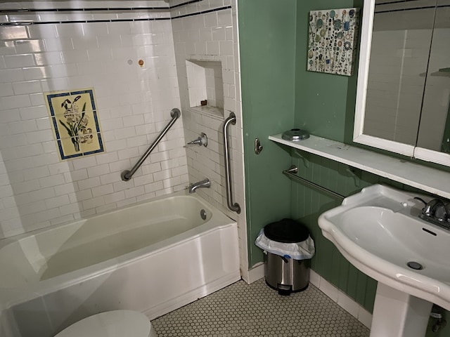 full bathroom featuring toilet, tiled shower / bath, sink, and tile patterned flooring