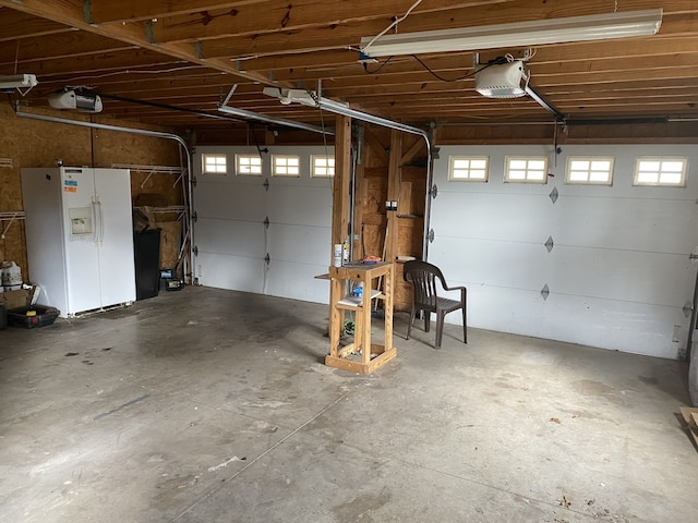 garage featuring a garage door opener and white refrigerator with ice dispenser