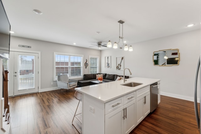 kitchen with dark hardwood / wood-style flooring, an island with sink, white cabinetry, stainless steel dishwasher, and sink