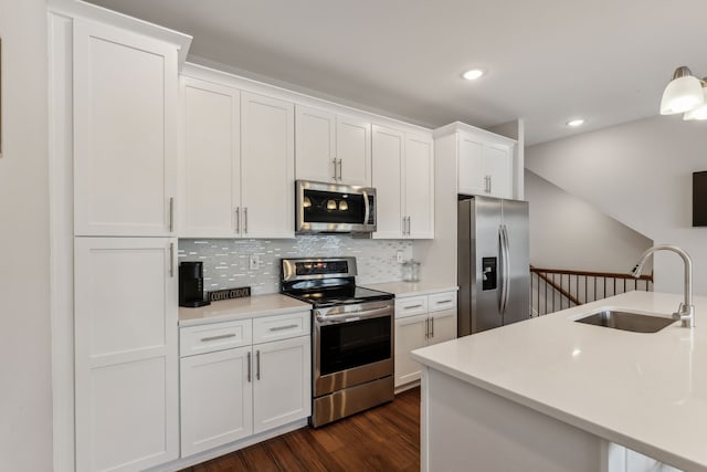 kitchen with white cabinets, backsplash, dark hardwood / wood-style flooring, sink, and stainless steel appliances