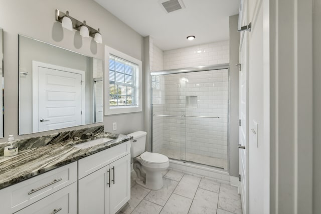 bathroom featuring toilet, a shower with shower door, and vanity