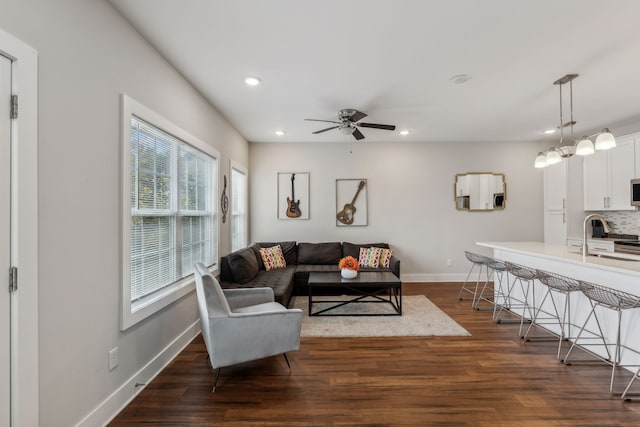 living room with sink, dark hardwood / wood-style floors, and ceiling fan