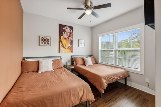 bedroom with dark hardwood / wood-style flooring and ceiling fan