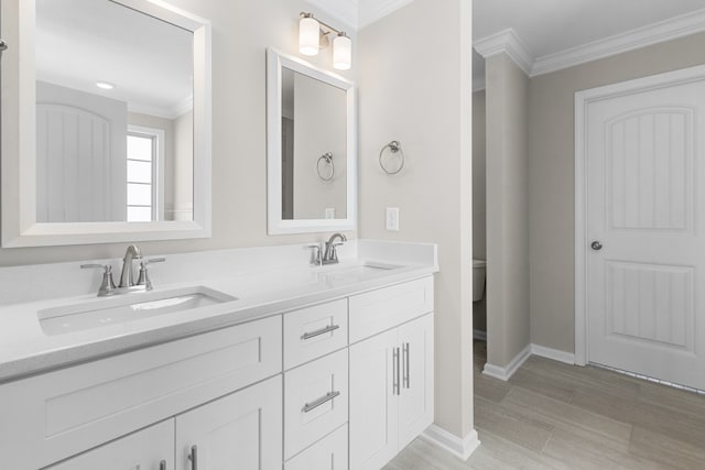 bathroom featuring vanity, ornamental molding, hardwood / wood-style flooring, and toilet