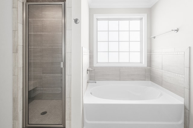 bathroom featuring ornamental molding, shower with separate bathtub, and a healthy amount of sunlight