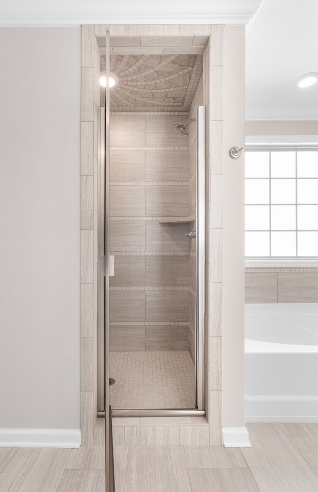 bathroom featuring crown molding, hardwood / wood-style flooring, and separate shower and tub