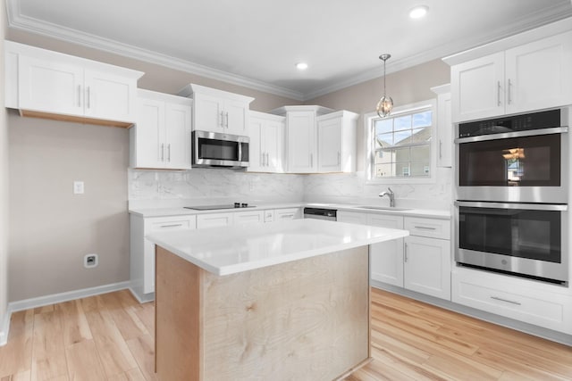 646 Woodrush Dr, Clarksville, TN 37040 - kitchen featuring appliances with stainless steel finishes, a sink, light wood-type flooring, light countertops, and crown molding