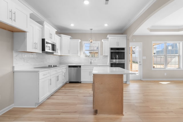 kitchen featuring pendant lighting, white cabinetry, stainless steel appliances, and light hardwood / wood-style floors