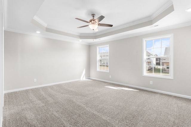 carpeted empty room featuring crown molding, a tray ceiling, and ceiling fan