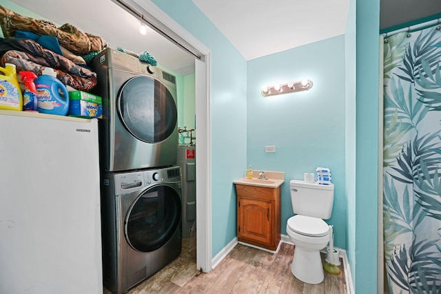 laundry area with sink, hardwood / wood-style floors, and stacked washer and clothes dryer