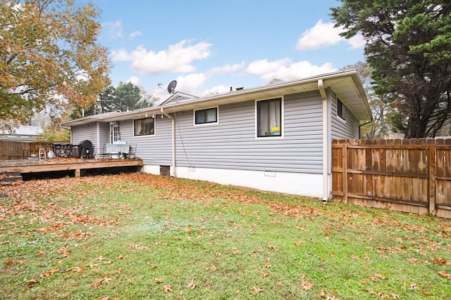 back of property featuring a deck and a yard